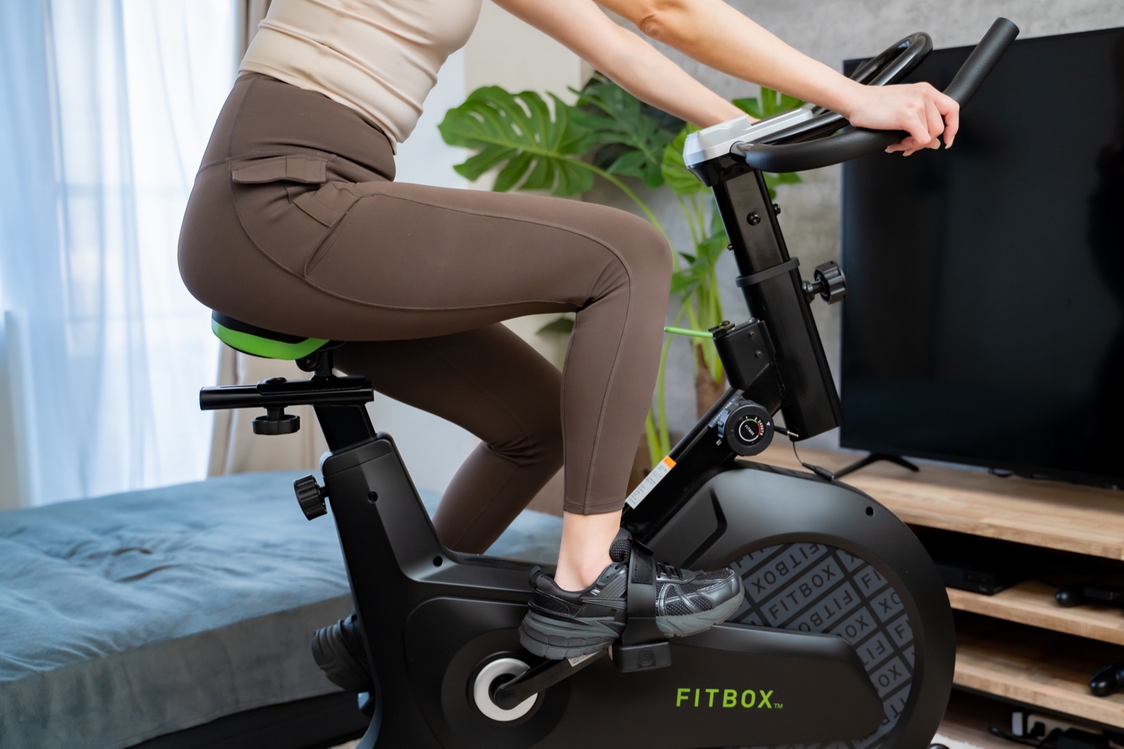 テレビの前でフィットネスバイク(FITBOX)を漕いでいるところ